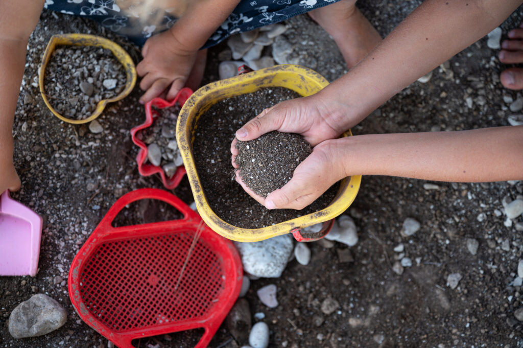 Kinder spielen mit Sand und Erde